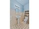 Cozy bathroom with pedestal sink, blue walls, and tiled floors at 1760 Old Bartow Eagle Lake Rd, Bartow, FL 33830