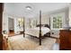 Spacious bedroom with four-poster bed, hardwood floors, and natural light from windows at 1760 Old Bartow Eagle Lake Rd, Bartow, FL 33830