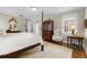 Bright bedroom featuring a four-poster bed, hardwood floors, and vintage-inspired furniture at 1760 Old Bartow Eagle Lake Rd, Bartow, FL 33830