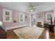 A sunlit room with hardwood floors, pastel pink walls, and white trim at 1760 Old Bartow Eagle Lake Rd, Bartow, FL 33830