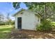 A white outbuilding with a black door and vintage light fixture at 1760 Old Bartow Eagle Lake Rd, Bartow, FL 33830