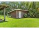 View of red brick outbuilding with white door on well manicured green lawn at 1760 Old Bartow Eagle Lake Rd, Bartow, FL 33830