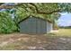 Gray corrugated metal outbuilding on concrete slab surrounded by lush greenery at 1760 Old Bartow Eagle Lake Rd, Bartow, FL 33830