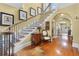 Elegant staircase with hardwood steps, iron railings, and views into adjoining rooms at 1760 Old Bartow Eagle Lake Rd, Bartow, FL 33830