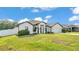 A charming single-story home with a well-kept lawn, complemented by a white fence and lush landscaping at 185 Heritage Park Ln, Mulberry, FL 33860