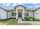 Inviting front entrance with a dark-colored door, modern lights, and freshly manicured landscaping at 185 Heritage Park Ln, Mulberry, FL 33860