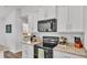 Modern kitchen with black appliances, bright countertops, and views into an adjacent bedroom at 185 Heritage Park Ln, Mulberry, FL 33860