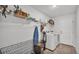 Well-organized laundry room with washer, dryer, storage shelves, and tile flooring at 185 Heritage Park Ln, Mulberry, FL 33860