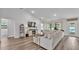 Cozy living room with vaulted ceilings, neutral tones, wood-look flooring, and a large sofa at 185 Heritage Park Ln, Mulberry, FL 33860