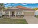 Inviting home with a charming front porch, a well-manicured lawn, and a two-car garage at 1925 Binnacle St, Kissimmee, FL 34744