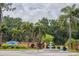 Community entrance with a water fountain, floral landscaping, and palm trees at 2055 S Floral Ave # 269, Bartow, FL 33830