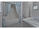 Cozy bathroom featuring a shower-tub combo with decorative curtain and neutral tile floor at 2085 Long Boat Dr, Lakeland, FL 33810
