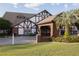 Charming clubhouse entrance featuring a brick facade, manicured landscaping, and palm trees at 2085 Long Boat Dr, Lakeland, FL 33810