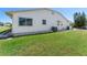 Exterior side view of the home featuring white siding and a well manicured green lawn at 2085 Long Boat Dr, Lakeland, FL 33810