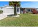 Charming single-story home featuring a well-manicured lawn, mature palm tree, and an attached screened garage at 2085 Long Boat Dr, Lakeland, FL 33810