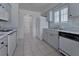Galley kitchen with white appliances, white cabinets, white tile floors, and lots of natural light at 2085 Long Boat Dr, Lakeland, FL 33810