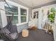 Charming front porch with a white hammock, gray hanging chair, and a natural wood-stained floor at 219 Ariana St # A-B, Lakeland, FL 33803