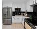 Modern kitchen with white cabinetry, stainless steel appliances, black subway tile backsplash, and light wood-look floors at 219 Ariana St # A-B, Lakeland, FL 33803