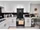 Modern kitchen featuring white cabinets, black backsplash, and stainless steel appliances at 219 Ariana St # A-B, Lakeland, FL 33803