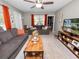 Inviting living room featuring two gray sofas, wood coffee table, ceiling fan, and light gray walls at 219 Ariana St # A-B, Lakeland, FL 33803