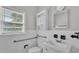 Bright bathroom features a white vanity, accessible grab bars, updated fixtures, and ample natural light at 2203 Avenue F Nw, Winter Haven, FL 33880