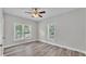 Bedroom featuring a ceiling fan, wood-look vinyl floors, and two windows providing natural light at 2203 Avenue F Nw, Winter Haven, FL 33880