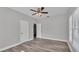Bedroom featuring a ceiling fan, wood-look vinyl floors, and closet space at 2203 Avenue F Nw, Winter Haven, FL 33880
