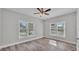 Bedroom featuring a ceiling fan, wood-look vinyl floors, and two windows providing natural light at 2203 Avenue F Nw, Winter Haven, FL 33880