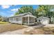 Charming home with a cozy screened porch and detached garage surrounded by a lush, green landscape at 2203 Avenue F Nw, Winter Haven, FL 33880