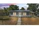 Charming single-story home featuring gray siding, a matching metal roof, and well-kept landscaping at 2203 Avenue F Nw, Winter Haven, FL 33880