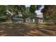 Evening view of the home and garage with mature trees providing shade at 2203 Avenue F Nw, Winter Haven, FL 33880