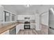 Well-lit kitchen features white cabinetry, stainless steel appliances, and updated flooring at 2203 Avenue F Nw, Winter Haven, FL 33880
