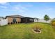 Large backyard with a screened lanai, white fence, and neatly trimmed shrubs and grass at 2726 Red Egret Dr, Bartow, FL 33830