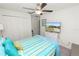 Comfortable bedroom featuring a striped bedspread, ceiling fan, TV, closet, and neutral decor at 2726 Red Egret Dr, Bartow, FL 33830