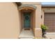 Close-up view of the teal front door with a wreath and stone landscaping with a two car garage on the right at 2726 Red Egret Dr, Bartow, FL 33830