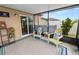 Cozy screened patio with colorful chairs and peaceful views of the fenced backyard at 2726 Red Egret Dr, Bartow, FL 33830