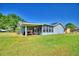Backyard with a screened patio, wooden picnic table, green grass, and plenty of open space at 2836 Magnolia Ave, Lakeland, FL 33812