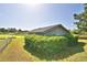 Wide backyard featuring a manicured hedge, green lawn, and a glimpse of the home's exterior at 2836 Magnolia Ave, Lakeland, FL 33812