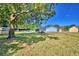 Expansive backyard featuring a mature tree, green grass, and a fire pit for outdoor enjoyment at 2836 Magnolia Ave, Lakeland, FL 33812
