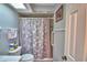 Bathroom featuring tiled shower with shower curtain, a toilet and towel rack at 2836 Magnolia Ave, Lakeland, FL 33812