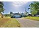 Single-story home with a long driveway, two-car garage, and lush green lawn at 2836 Magnolia Ave, Lakeland, FL 33812