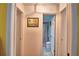 Bright hallway leads to a tiled bathroom with a shower behind a patterned shower curtain at 2836 Magnolia Ave, Lakeland, FL 33812
