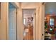 Hallway view leads to a sunlit bedroom and a cozy living room with wood paneling at 2836 Magnolia Ave, Lakeland, FL 33812