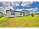 A green backyard offering space for outdoor activities, with a view of nearby homes under a bright sky at 3208 Weitzel Dr, Haines City, FL 33844