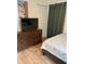 Bright bedroom features a dresser with television, decor, and wood-look flooring at 3227 Decatur Ave, Lakeland, FL 33805