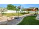 Landscaped backyard with a brick fire pit, basketball court, and covered patio at 3425 Sutton Ridge St, Lakeland, FL 33810