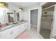 Well-lit bathroom featuring double sinks with granite countertops, a walk-in shower, and modern fixtures at 3425 Sutton Ridge St, Lakeland, FL 33810