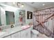 Well-lit bathroom featuring double sinks, granite counters, and a shower with star-themed curtain at 3425 Sutton Ridge St, Lakeland, FL 33810