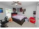 Bedroom with a dark wood frame bed, carpet flooring, and a ceiling fan at 3425 Sutton Ridge St, Lakeland, FL 33810