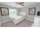 Neutral bedroom with palm tree art, a ceiling fan, carpet, and natural light at 3425 Sutton Ridge St, Lakeland, FL 33810
